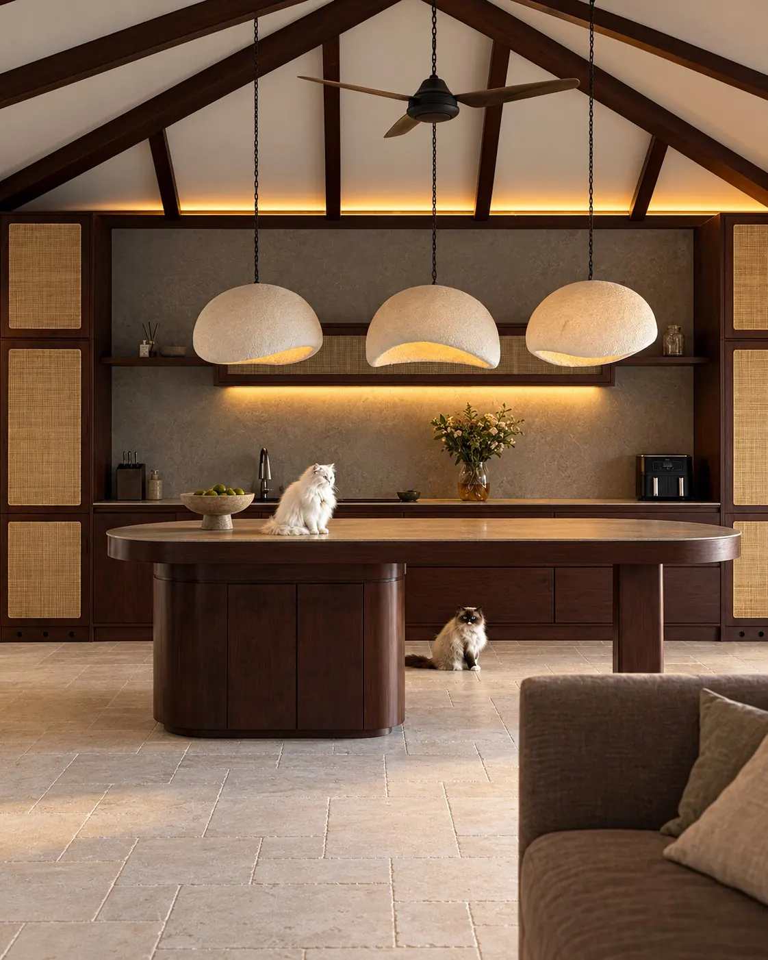 The kitchen: three plaster pendant lamps over a walnut island with a stone top, rattan cabinet fronts, exposed roof beams